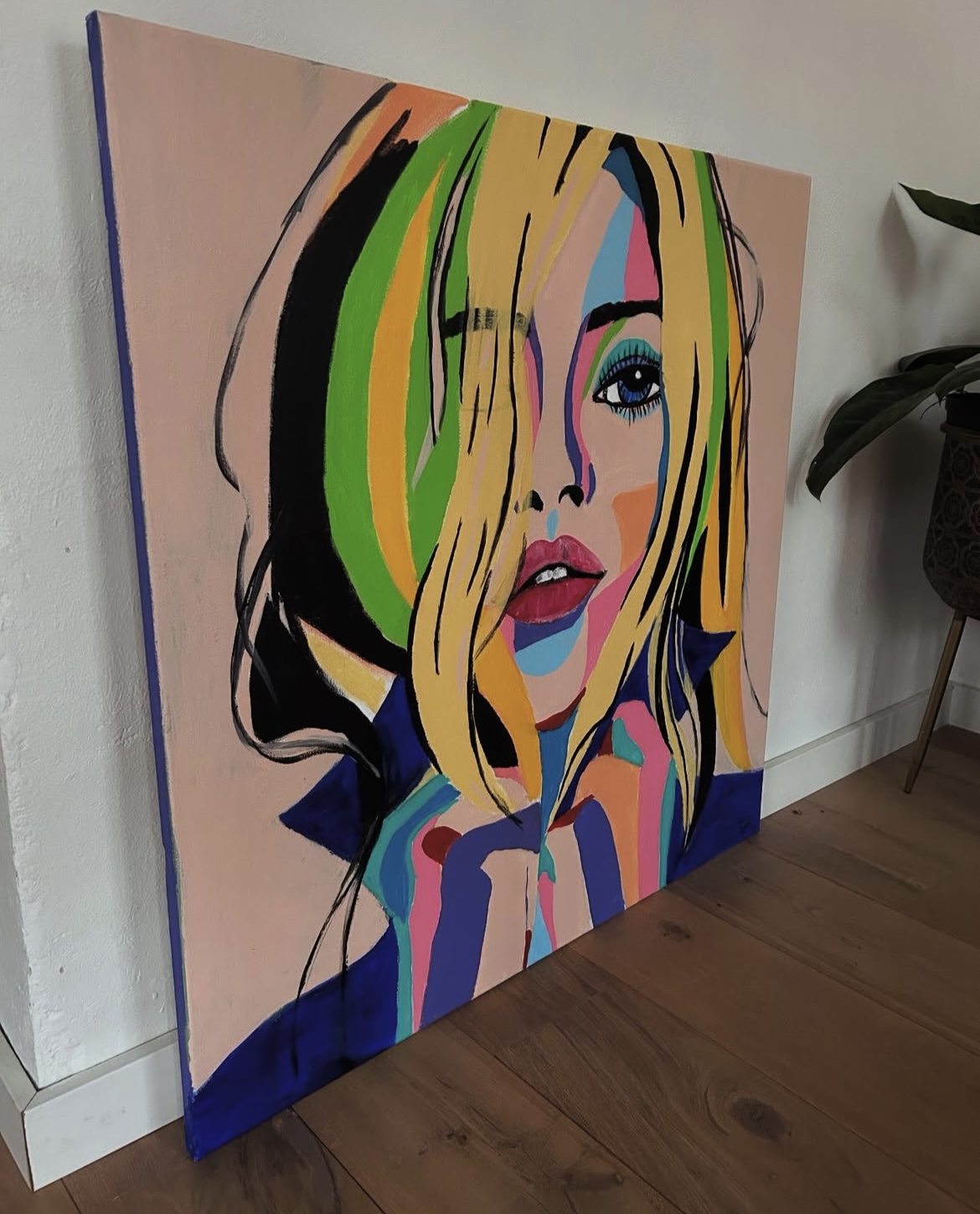 Colourful portrait painting of a blonde woman with green, yellow and blue shapes on a pink background