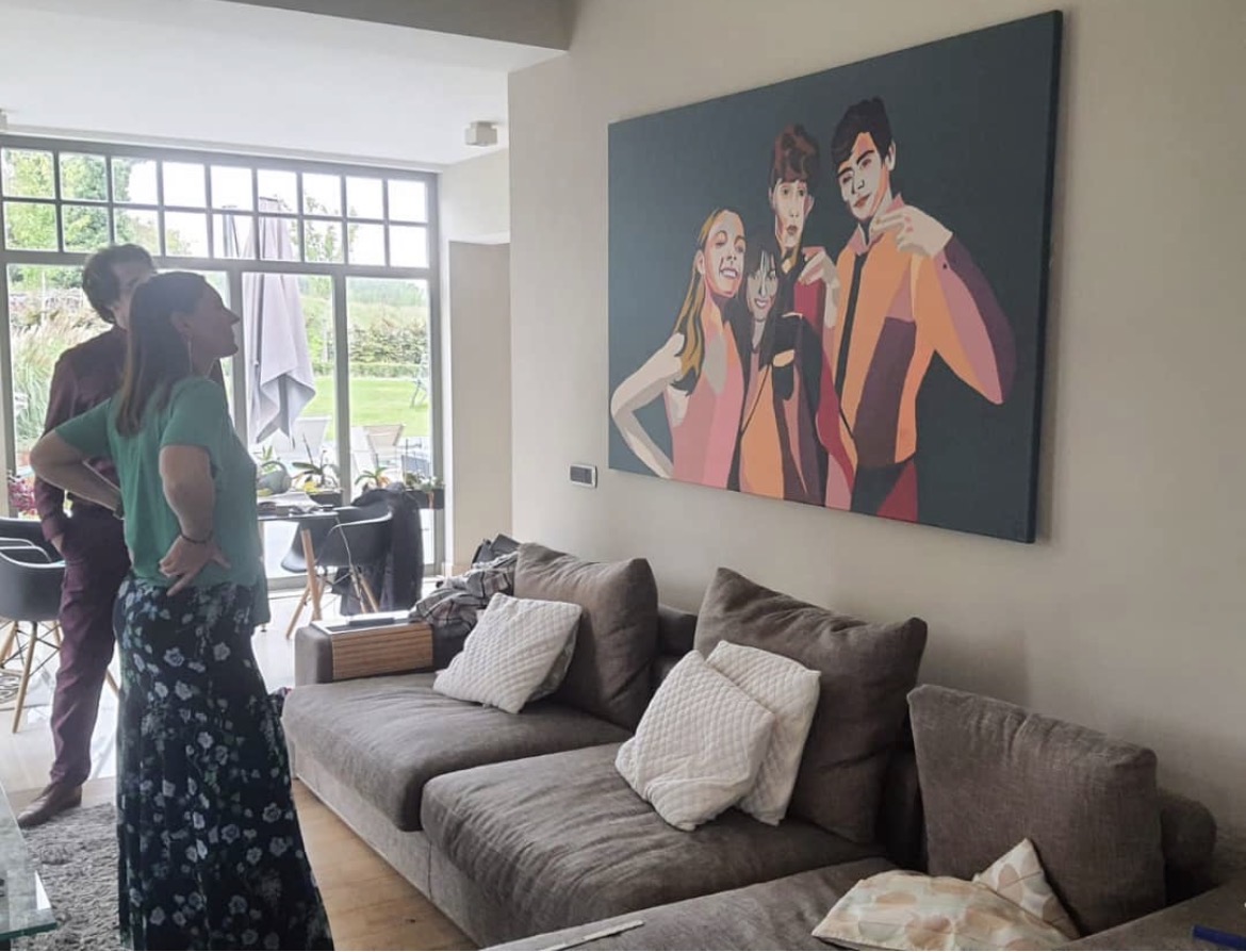 Large commissioned family portrait in coral and teal hanging above a sofa
