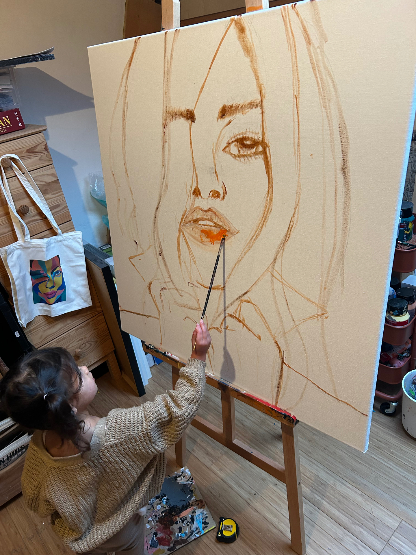 Fabienne painting a large portrait in her studio